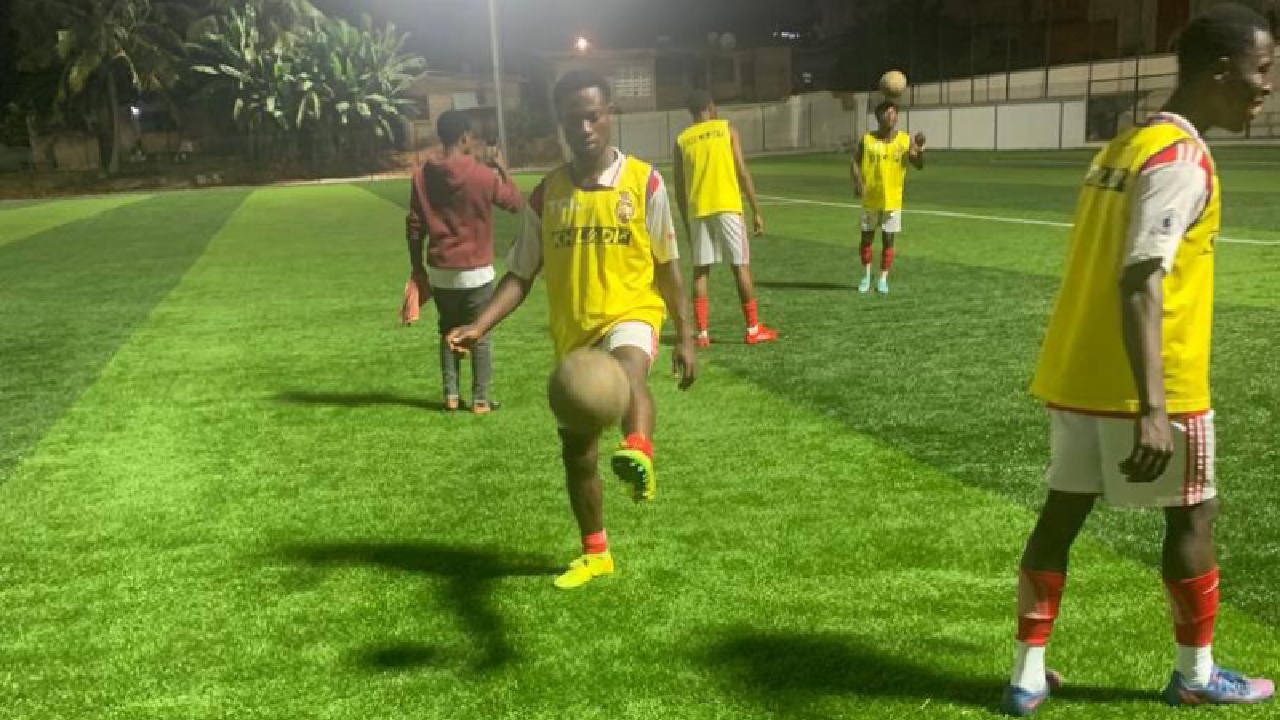 Group Of Male High School Students With Coach Playing In Soccer Team